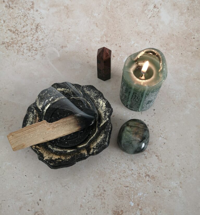 Räucherwerk – brennendes Palo Santo mit Kerze und Kristallen