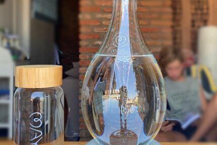 MAYU Glasflasche mit Bambusdeckel neben der MAYU Swirl Karaffe auf dem Tisch